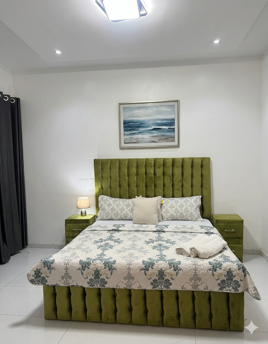 Second bedroom with olive velvet bed, artwork and private balcony